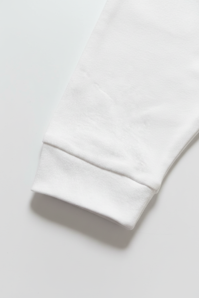 Vita enfärgade babybyxor – närbild på muddar, vit bakgrund